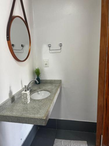 a bathroom with a sink and a mirror at Casa de praia em Fortim CE com ótima localização e fácil acesso in Fortim