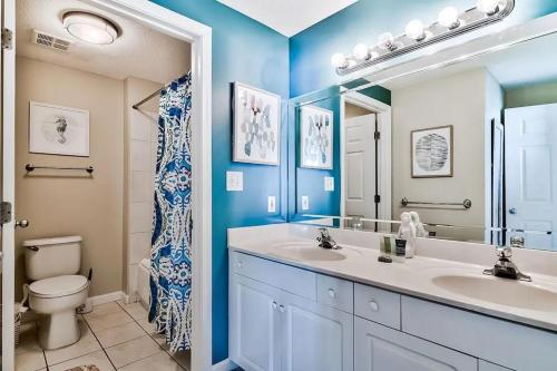 a bathroom with two sinks and a toilet and a mirror at Majestic Sun 202B in Destin