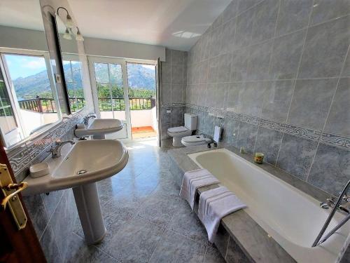 a bathroom with a tub and a sink and two toilets at INcostadamorte Corral da Laxe in Dumbría
