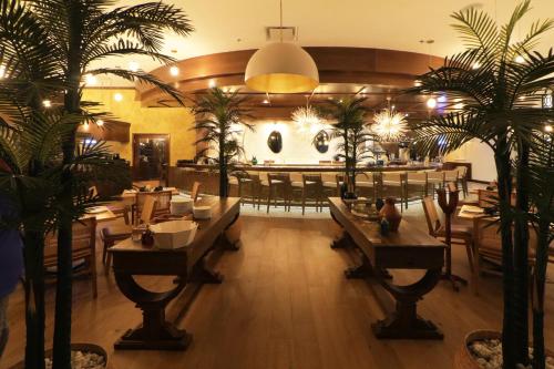 a restaurant with tables and chairs and palm trees at Culiacan Marriott Hotel in Culiacán