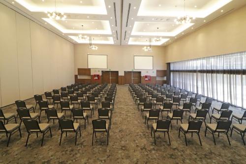 a room with rows of chairs in a room with windows at Culiacan Marriott Hotel in Culiacán