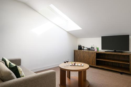 a living room with a tv and a coffee table at Inspira Liberdade Boutique Hotel in Lisbon