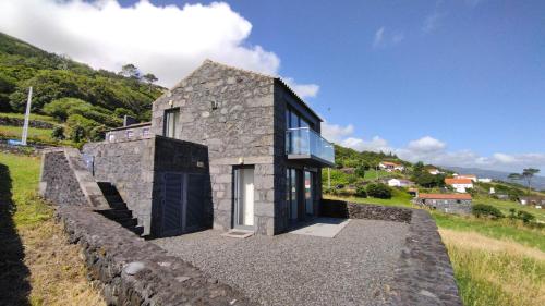 a stone house on the side of a hill at Casas Goulart in Canto da Areia