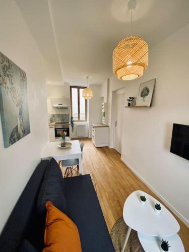 un salon avec un canapé bleu et une table dans l'établissement Jolie T2. Proche centre ville, aquensis et thermes, à Bagnères-de-Bigorre