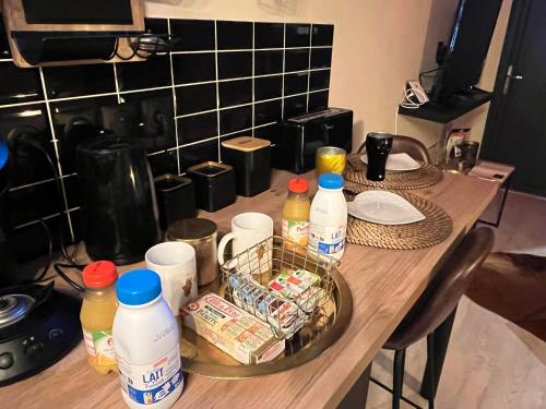 una mesa con botellas y recipientes de comida. en La tentation, en Berck-sur-Mer