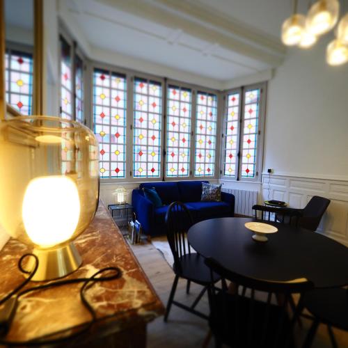 un salon avec un canapé, une table et des chaises dans l'établissement Appartement de charme Art Déco, à Vichy