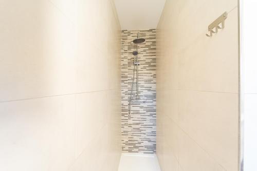 y baño con ducha y pared de piedra. en Apartamento Jibazahora B1, en Zahora