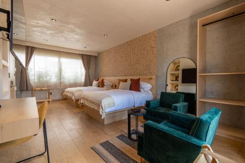 a bedroom with a bed and a couch and a chair at Boutique Hotel Durango219 in Mexico City