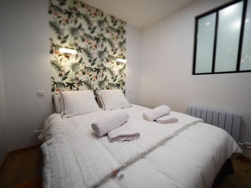 sypialnia z łóżkiem i dwoma ręcznikami na nim w obiekcie Appartement de charme Art Déco w mieście Vichy