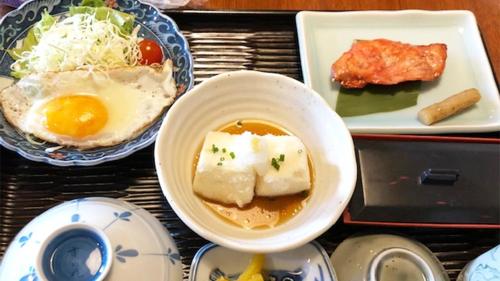 a tray with a bowl of soup and a plate of food at Kagetsu Ryokan in Shizuoka