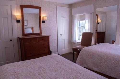 a hotel room with two beds and a mirror at Franconia Inn in Franconia