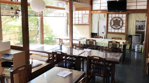 a restaurant with tables and chairs and a large window at Kagetsu Ryokan in Shizuoka
