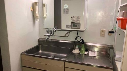 a kitchen with a stainless steel kitchen sink at Kagetsu Ryokan in Shizuoka