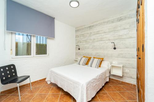 um quarto com uma cama e uma cadeira em Apartamento Jibazahora B3 em Zahora