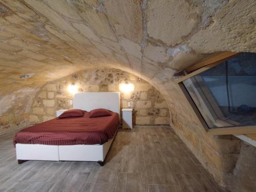 a bedroom with a bed in a stone wall at Au 47 in Bordeaux