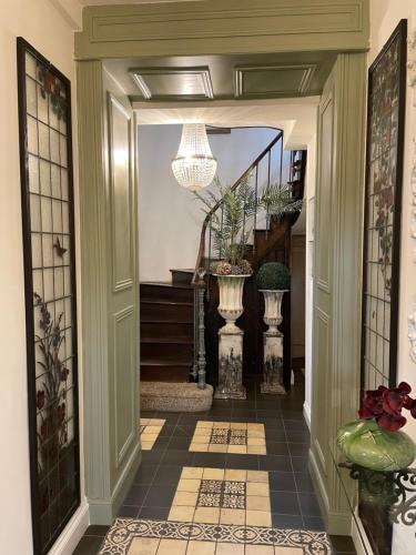 a hallway with a tile floor and a chandelier at Maison Hirondelles Hôtes in Mézières-sur-Issoire