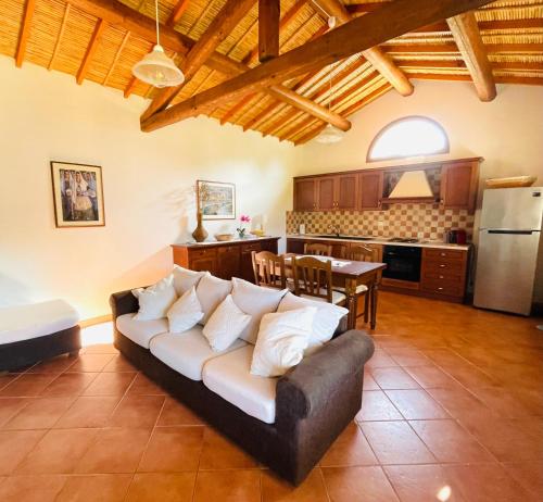 Una sala de estar con un sofá y una cocina. en Asfodeli house, en Teulada