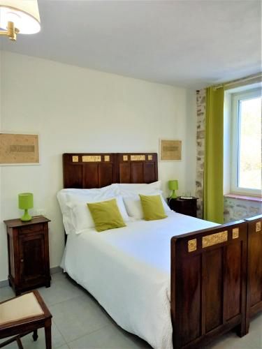 a bedroom with a large white bed with green accents at Agriturismo Malvista in San Sebastiano Curone