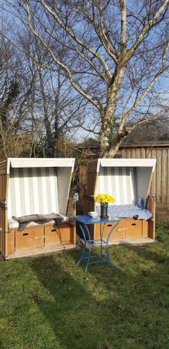 a picnic table and a bench in a yard at HeidAway Sylt - Schönes Appartment mit Terrasse/Garten in Braderup