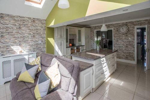 a living room with a couch and a kitchen at Sleepy Rock in Dungarvan