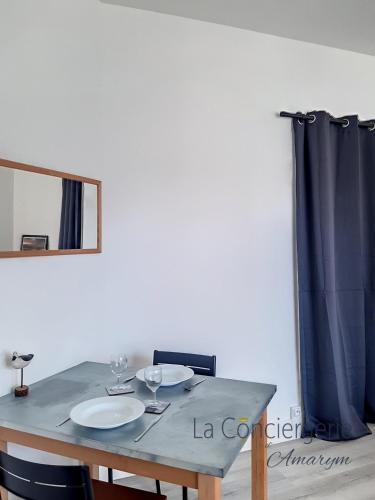 - une table à manger avec 2 assiettes et un miroir dans l'établissement AS 33 - La sirène d'Onival, à Ault
