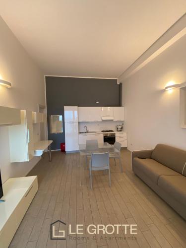 a living room with a couch and a table at Tramonto - Le Grotte Rooms & Apartments in Camerano