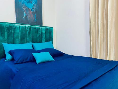 a blue bed with a green headboard and blue pillows at Private Room near Istanbul Airport 2 in Arnavutköy