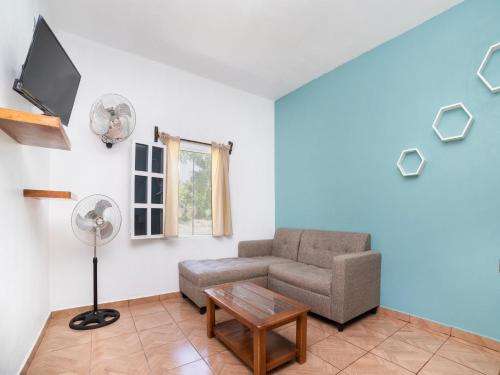 a living room with a couch and a fan at Villas el Paraíso, El Rollo in Tlaquiltenango