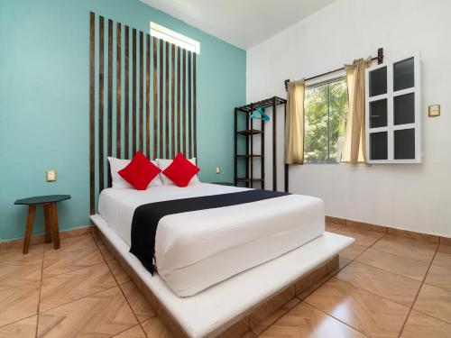 - une chambre avec un grand lit blanc et des oreillers rouges dans l'établissement Villas El Paraiso, à Tlaquiltenango