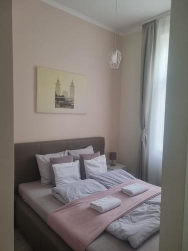a bedroom with a large bed with two pillows at Eden Center Home in Győr