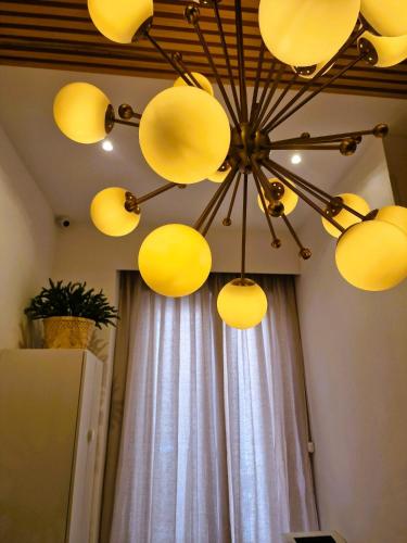 un lampadario a braccio con luci gialle appeso a un soffitto di Hostal Comercial a Madrid