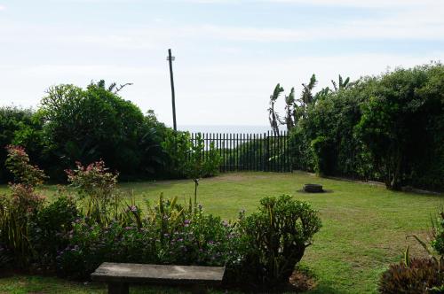a park with a bench and a fence and flowers at 9 Seesonnet Scottburgh in Scottburgh
