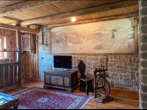 ein Wohnzimmer mit einem großen Gemälde an der Wand in der Unterkunft Chalet La Rite Dolomiti in Masariè