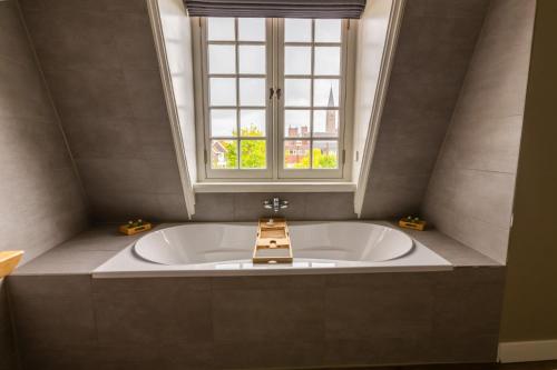 a large bath tub in a room with a window at Hotel Inn Naeldwyk in Naaldwijk