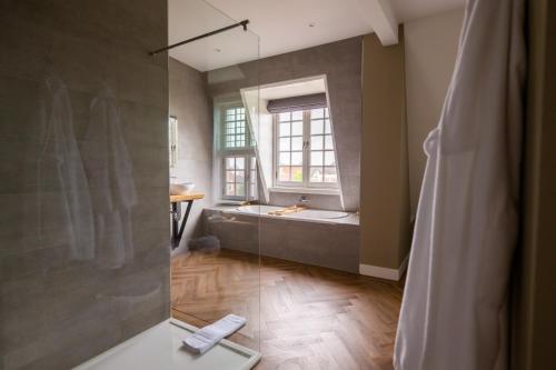 a bathroom with a shower with a tub and a window at Hotel Inn Naeldwyk-Torenburg in Naaldwijk