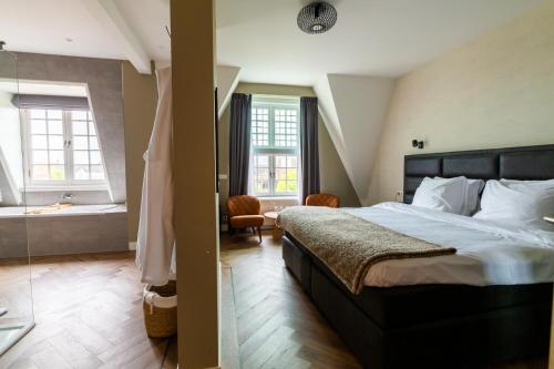 a bedroom with a large bed and a bath tub at Hotel Inn Naeldwyk-Torenburg in Naaldwijk