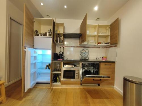 una cocina con armarios de madera y electrodomésticos de acero inoxidable en Au 47 en Burdeos