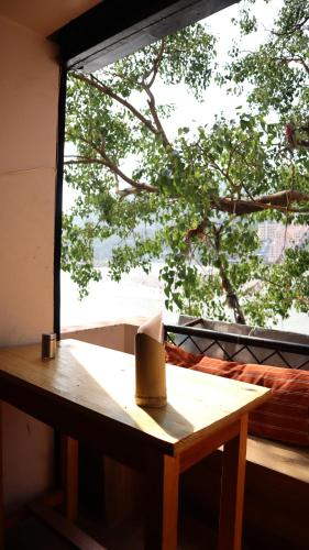 een houten tafel voor een raam bij Capt. Mount Stays in Rishīkesh