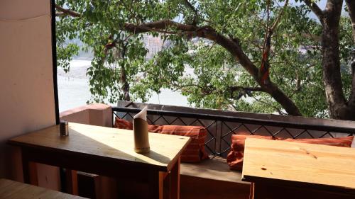 een tafel en stoelen op een balkon met een boom bij Capt. Mount Stays in Rishīkesh