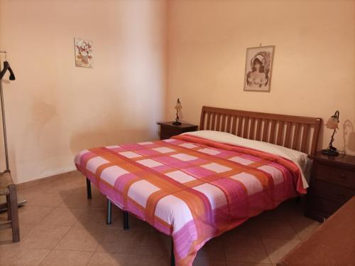 ein Schlafzimmer mit einem Bett mit einer gestreiften Decke in der Unterkunft Rifugio Mareneve le Villette in Linguaglossa