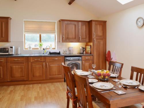 a kitchen with a wooden table and a dining room at Greengage in Lissett