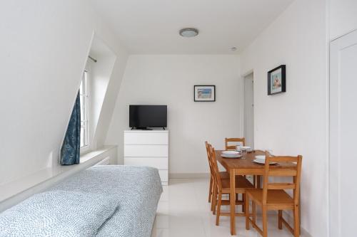 a bedroom with a bed and a table and chairs at Bourget RER Studio 2ème droite in Le Bourget