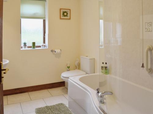 a bathroom with a tub and a toilet and a sink at Greengage in Lissett