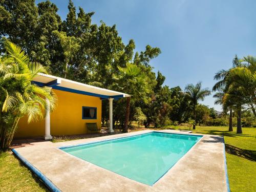 a swimming pool in front of a house at Villas el Paraíso, El Rollo in Tlaquiltenango