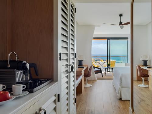 a kitchen and living room with a view of the ocean at H10 Atlantic Sunset Horizons Collection in Adeje