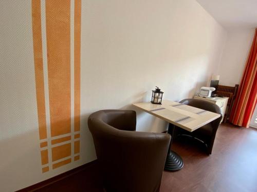 a dining room with a table and two chairs at Küstenapartment 2 in Gelbensande