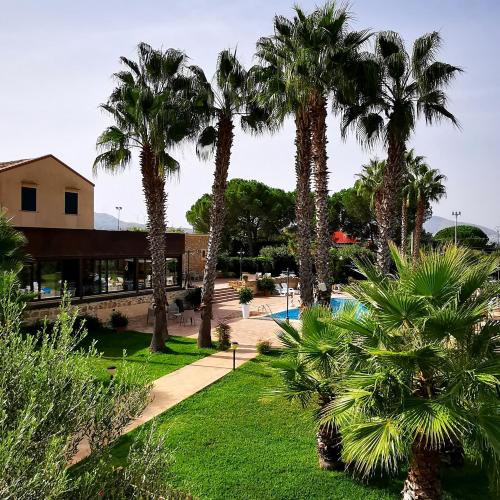 ośrodek z palmami i basenem w obiekcie Azienda Agrituristica Baglio Carta w mieście Balestrate