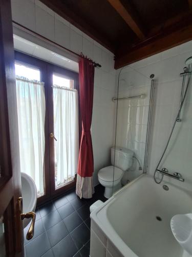 a bathroom with a tub and a toilet and a sink at Hotel La Balsa in Cangas de Onís