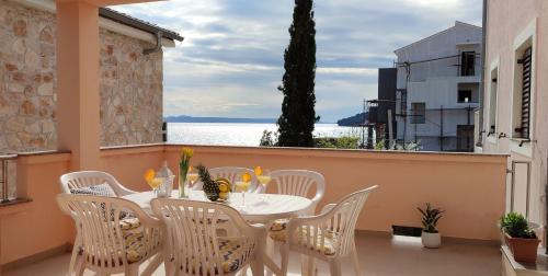 d'une table et de chaises sur un balcon avec vue sur l'eau. dans l'établissement Sea Breeze Suite - Beachfront, à Kali