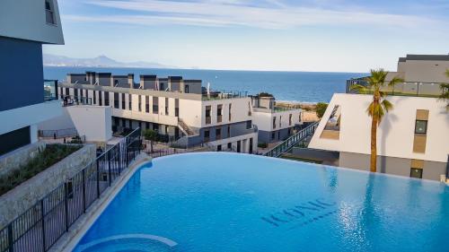 een zwembad aan de zijkant van een gebouw met uitzicht op de oceaan bij Iconic Sea Views Luxury Apartment in Puerto Marino